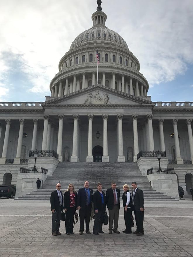 The group takes a break from meetings for a picture outside the Capitol Building.