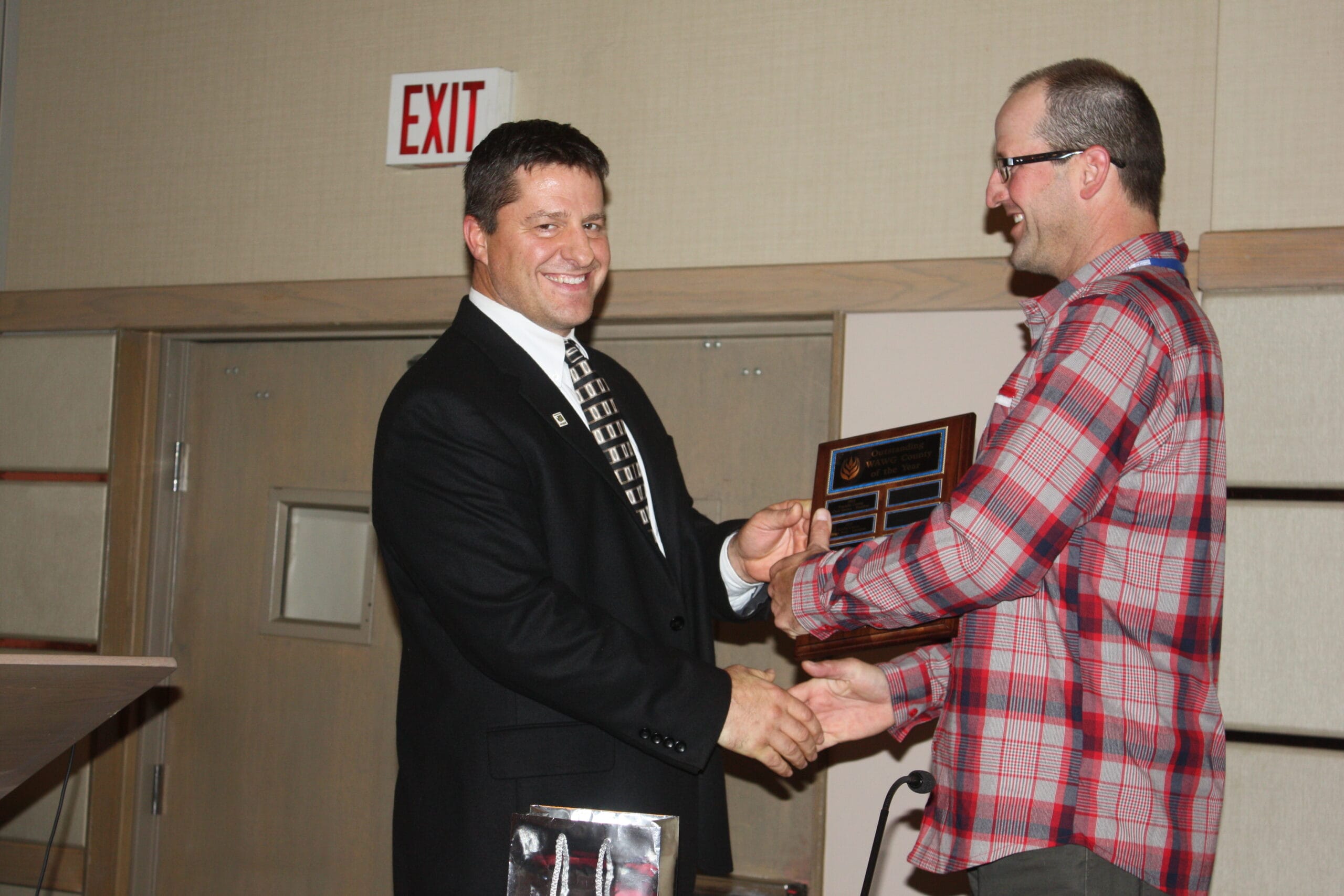 Outgoing WAWG president Kevin Klein (left) named Benton County as the WAWG county of the year. County president Tony Smith accepts the award.