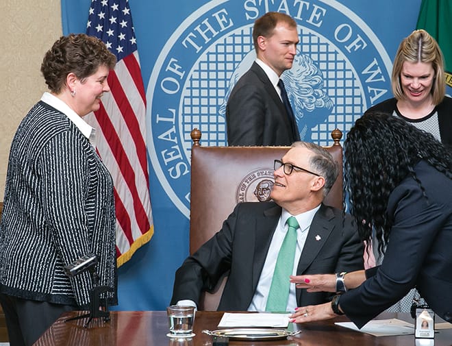 Marci Green (left), vice president of the Washington Association of Wheat Growers (WAWG), speaks with Gov. Jay Inslee during the signing of SSB 5051, a bill that triples the amount of time the Washington State Department of Natural Resources is required to give notice when terminating agricultural or grazing leases early. WAWG lobbyist Diana Carlen (far right) also attended the signing. Photo courtesy of the Washington State Legislative Support Services.