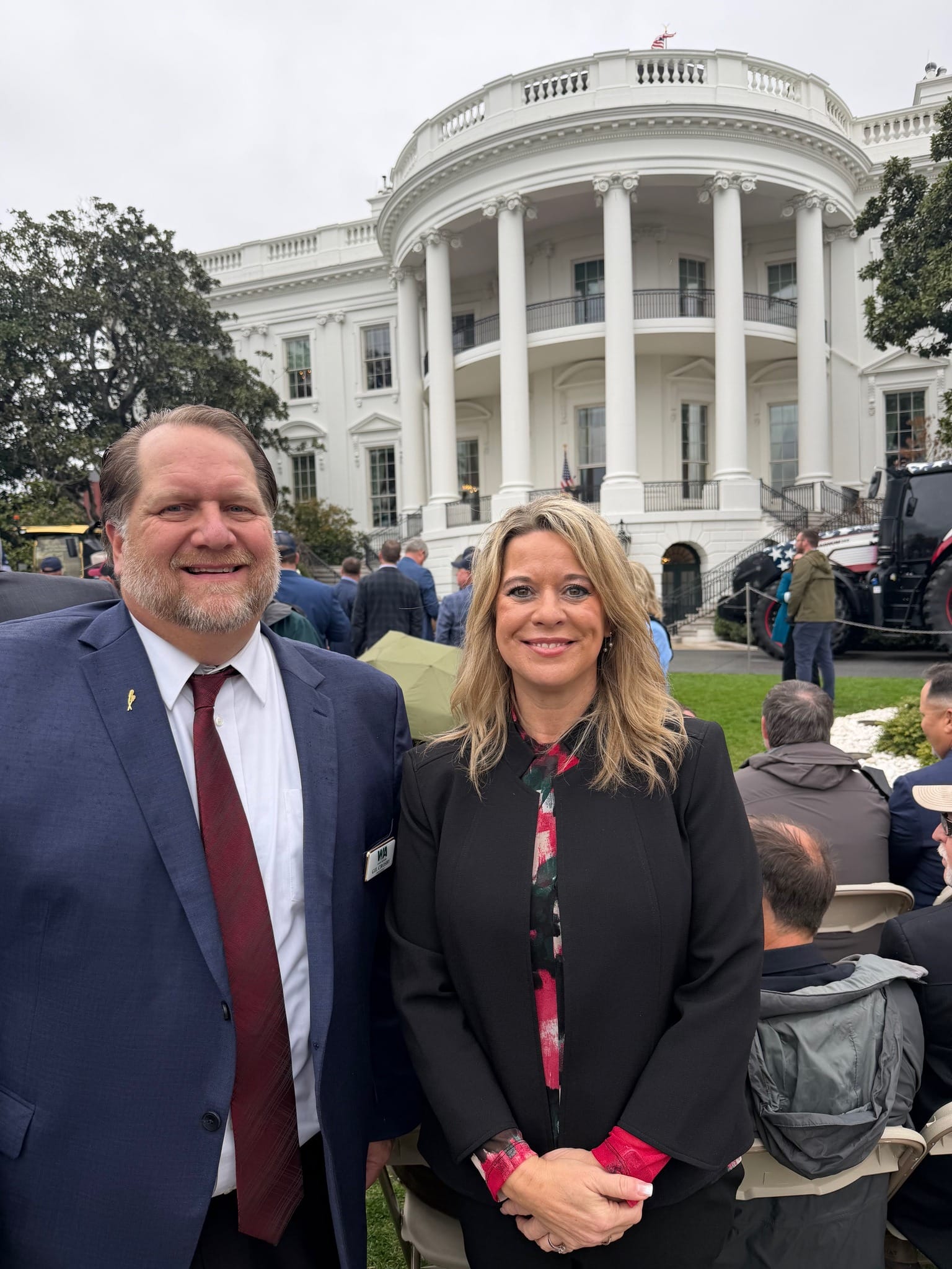 Two people posing in front of White House