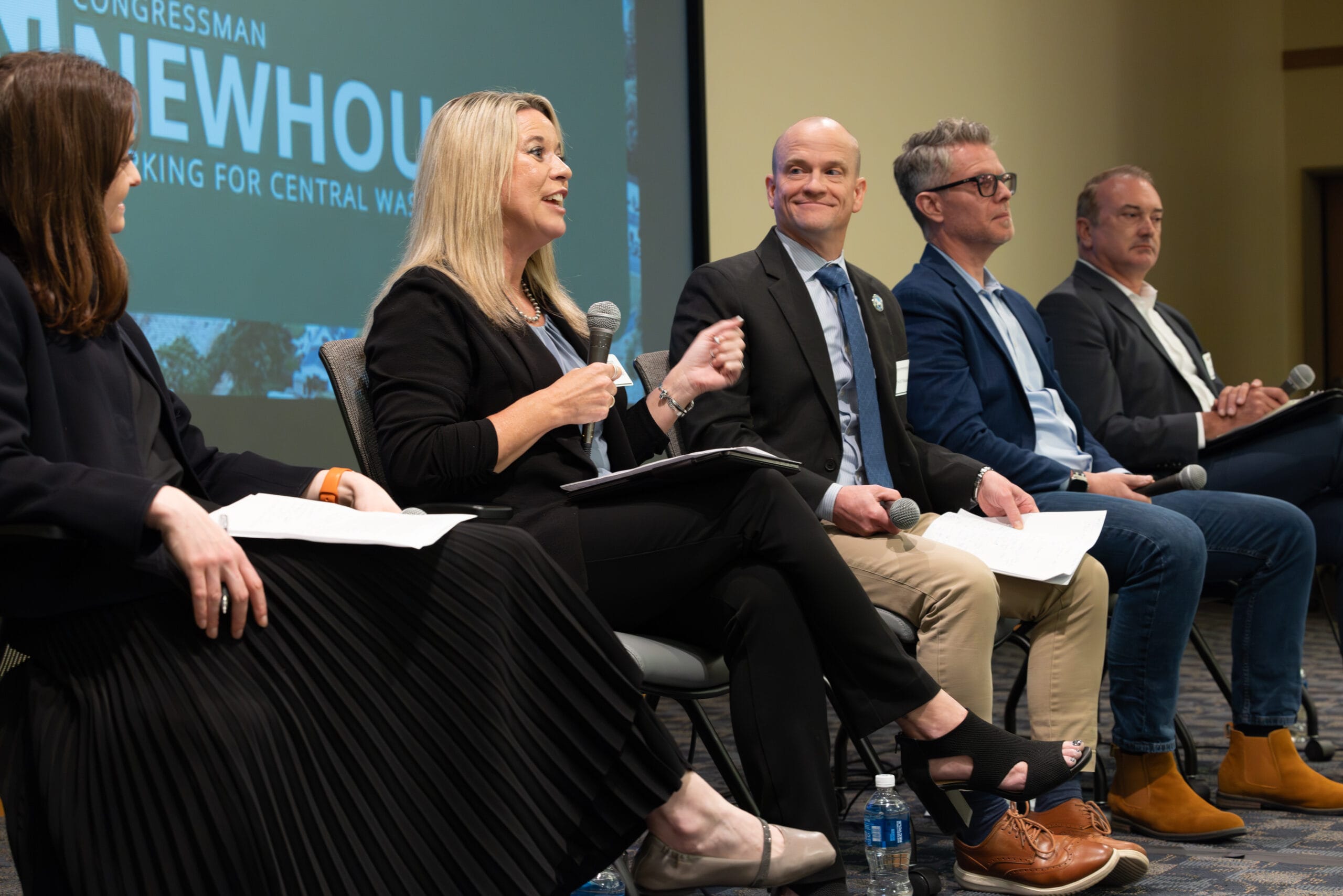 Panel discussion with speakers holding microphones on stage
