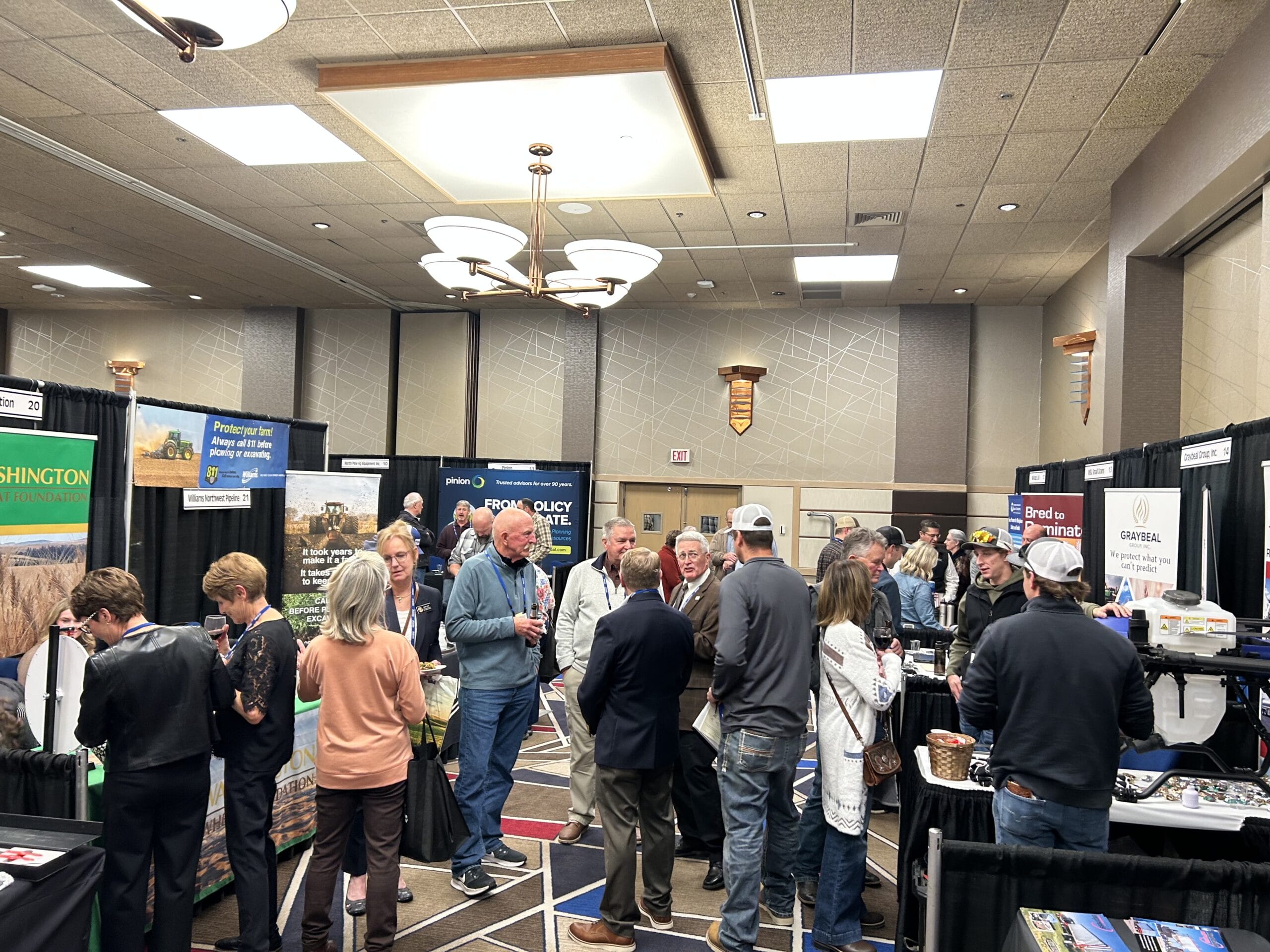 Attendees networking at indoor agricultural trade show booths