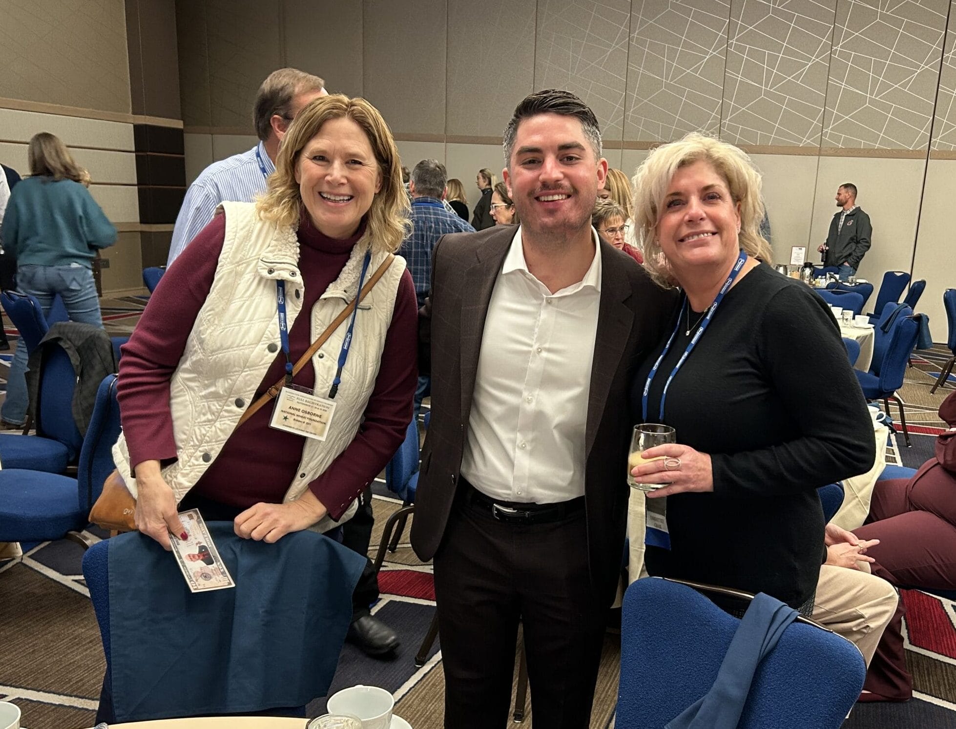 Three colleagues smiling at conference banquet table